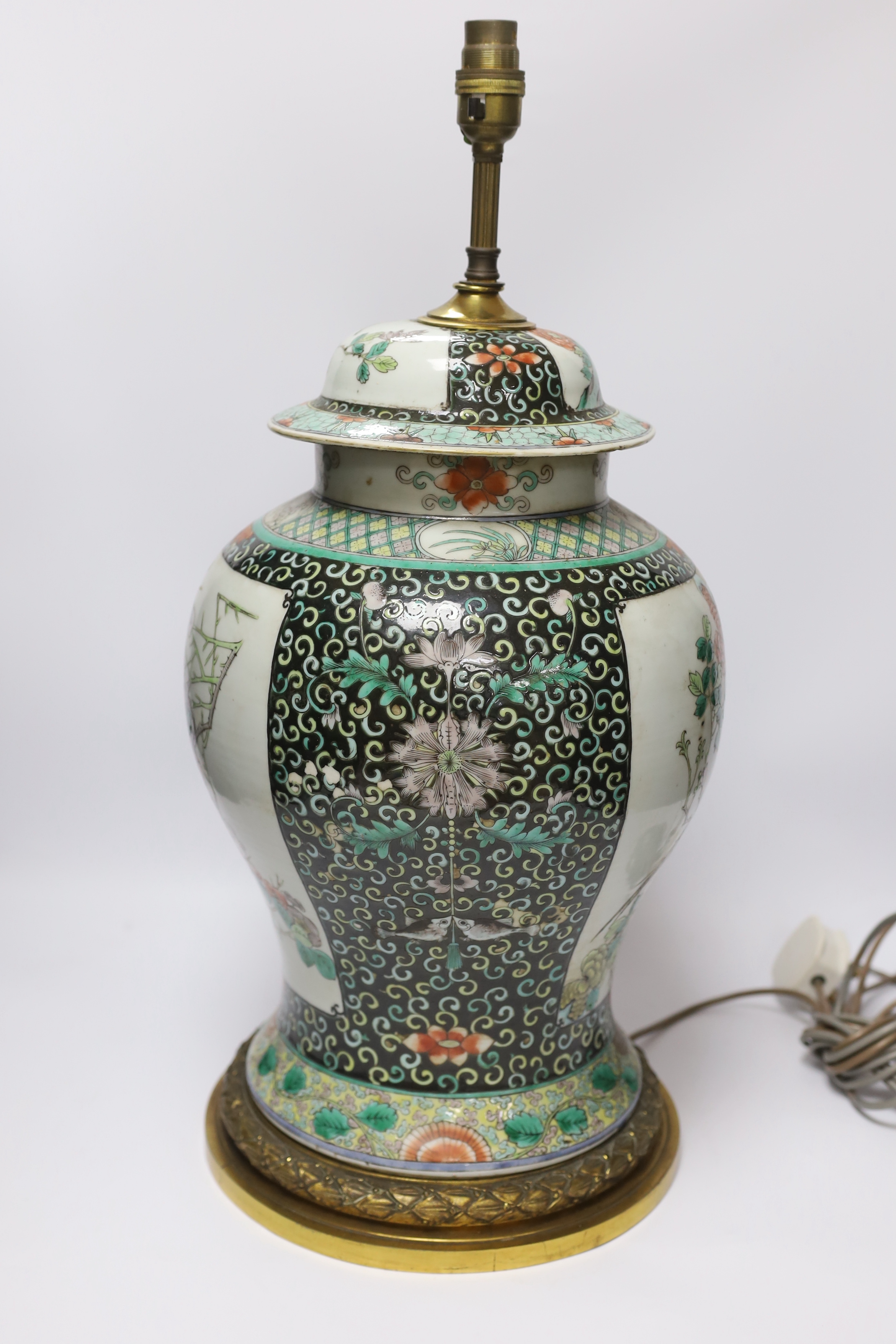 A Chinese famille verte porcelain baluster vase and cover, 19th century, decorated with birds amongst branches and blossom on decorative gilt metal base (now converted to a table lamp and drilled), 56cm total